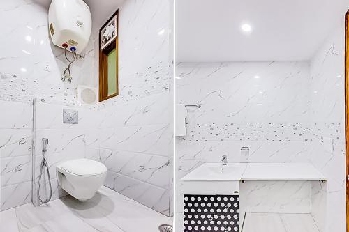 a white bathroom with a toilet and a sink at Hotel Satguru - Dwarka Mor Metro in New Delhi