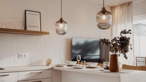 a kitchen with pendant lights and a table with dishes at Urban Suite - Detmold in Detmold