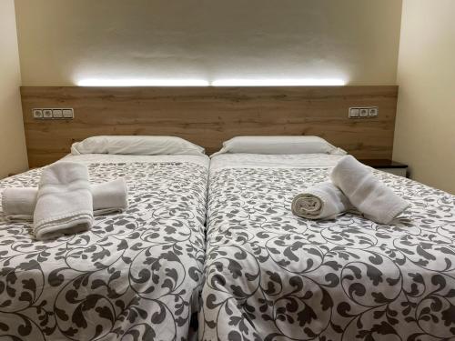 1 dormitorio con 2 camas y toallas. en Vivienda Familiar junto Plaza Toros de Teruel, en Teruel