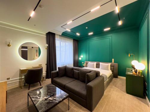 a bedroom with a bed and a couch and a table at Bentley Hotel Tashkent in Tashkent