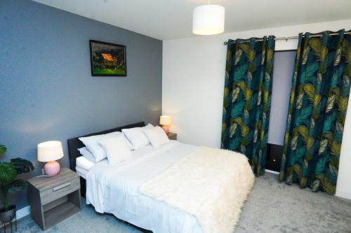 a bedroom with a white bed and blue walls at Stylish Airport Apartment in Luton