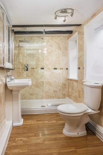 a bathroom with a toilet and a sink and a tub at The Pied Bull in Chester