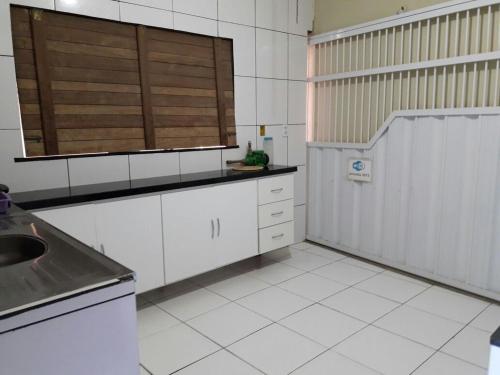- une cuisine avec des placards blancs et un évier dans l'établissement Casa L&A 01, à Aracati