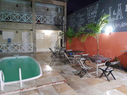 Cette chambre dispose d'une baignoire, de tables et de chaises. dans l'établissement Casa L&A 01, à Aracati