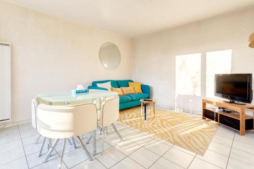 un salon avec un canapé bleu et une télévision dans l'établissement T2 Massy Vilmorin 3 min Gare RER TGV, à Massy