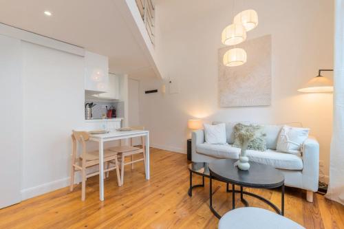 een woonkamer met een bank en een tafel bij Charming renovated and bright studio in the center in Lille