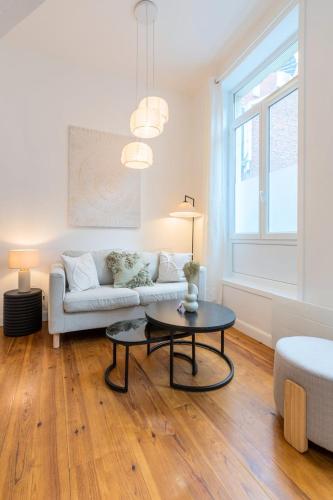un salon avec un canapé et une table dans l'établissement Charming renovated and bright studio in the center, à Lille