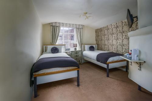 a bedroom with two beds and a window at The Pied Bull in Chester