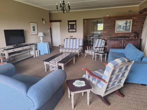 ein Wohnzimmer mit einem blauen Sofa und Stühlen in der Unterkunft Ukuthula Blissful Breakaways in Margate