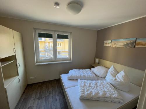 a bedroom with two beds and a window at Küstenbrise 1 in Graal-Müritz
