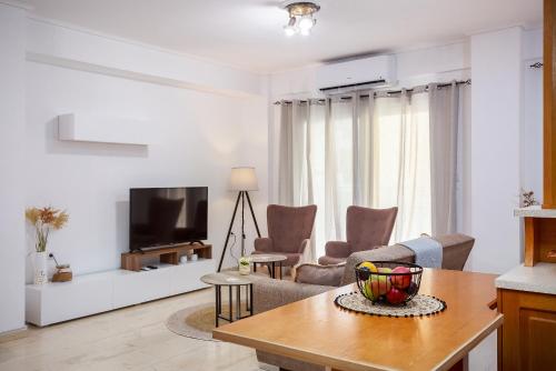 a living room with a couch and a tv at Harmony home in Ierápetra