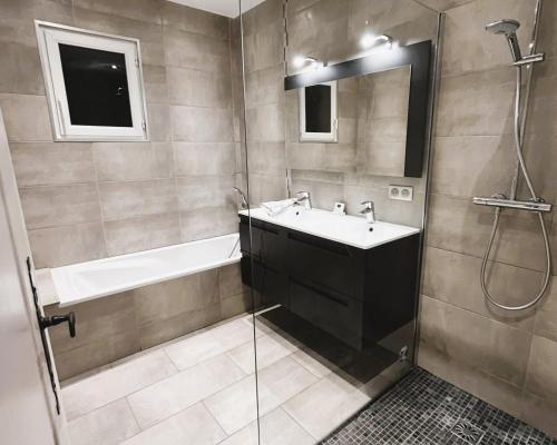 La salle de bains est pourvue d'un lavabo, d'une baignoire et d'une douche. dans l'établissement VILLA MARILOU climatisée pour 6 personnes avec piscine sur le Domaine de Valcros à la Londes-Les-Maures, à La Londe-les-Maures