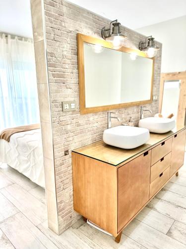 a bathroom with two sinks and a mirror at CASA RURAL AREV in Herrera del Duque