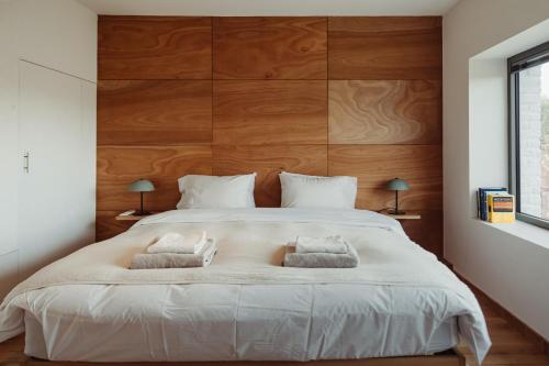 a bedroom with a large white bed with two pillows at Maison Coucou in Thuin