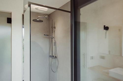 a shower with a glass door in a bathroom at Maison Coucou in Thuin
