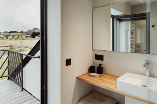 La salle de bains est pourvue d'un lavabo et d'un miroir. dans l'établissement Maison Coucou, à Thuin