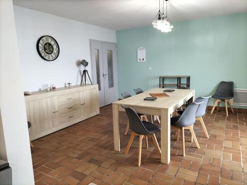 a kitchen and dining room with a table and chairs at L'Atlantique Appartement en front de mer in Jard-sur-Mer