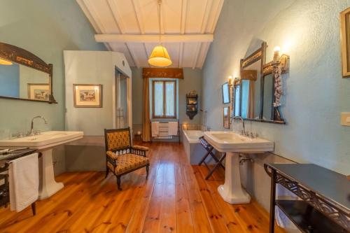 a large bathroom with two sinks and a chair at Podere Manafiore in Monticchiello