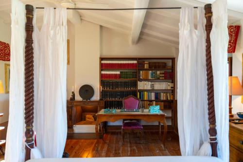 a bedroom with a table and a book shelf with books at Podere Manafiore in Monticchiello