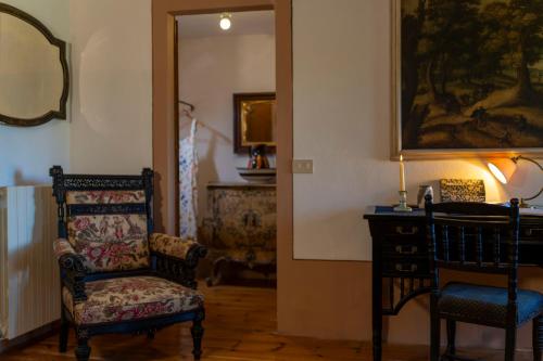 a living room with a chair and a mirror at Podere Manafiore in Monticchiello