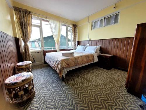 Habitación de hotel con cama y ventana en Seven Pines, en Darjeeling
