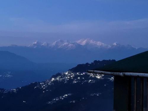 Una vista de una ciudad en una colina con montañas en el fondo en Seven Pines, en Darjeeling