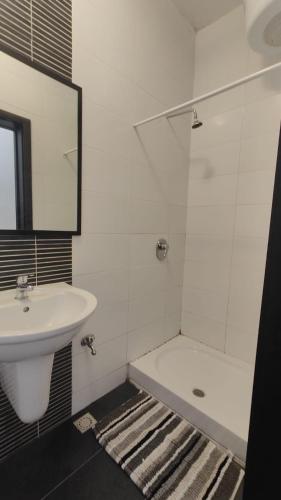 a white bathroom with a sink and a bath tub at Super Located Ground Floor Apartment in St. Julianʼs