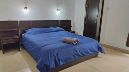 a bed with a blue blanket and a towel on it at Super Located Ground Floor Apartment in St. Julianʼs