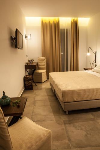 a hotel room with two beds and a couch at Anemos Rooms & Apartments in Nafplio