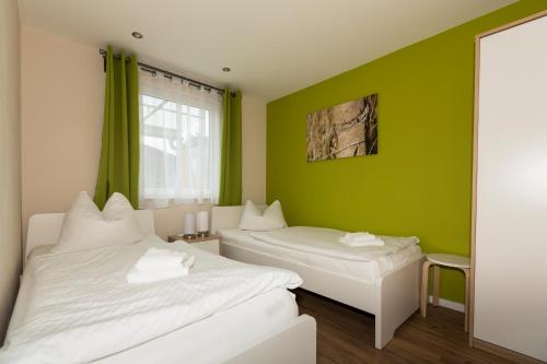 two beds in a room with green walls at Ferienhaus Zauneidechse im Sternenpark in Lochow