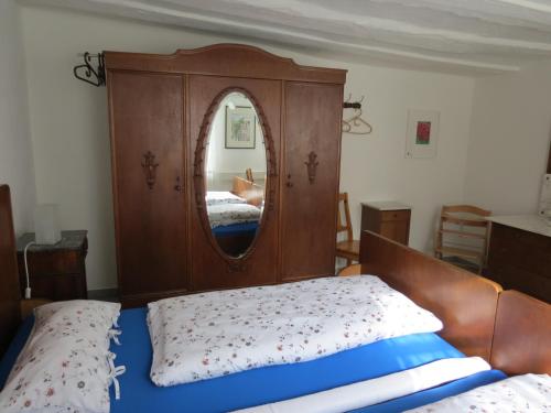 a bedroom with a wooden headboard and a mirror at Im Alten Kaufhaus in Rhodt unter Rietburg