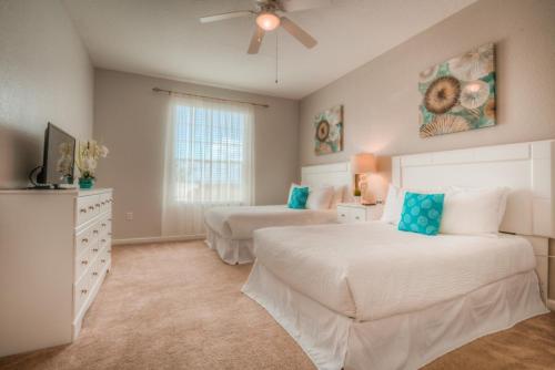 um quarto com 2 camas e uma ventoinha de tecto em Vista Cay 70 by Top Villas em Orlando