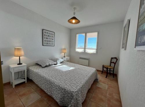 une chambre avec un lit et deux tables et une fenêtre dans l'établissement Flo vue mer, à Valras-Plage