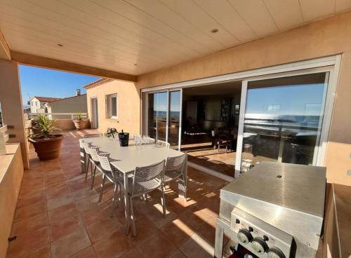 une cuisine avec une table et des chaises sur une terrasse dans l'établissement Flo vue mer, à Valras-Plage