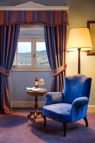 a blue chair and a table in a room with a window at Villa La Massa in Bagno a Ripoli