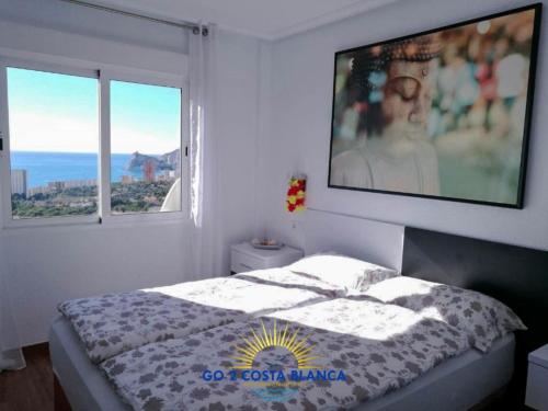 Schlafzimmer mit einem Bett und einem großen TV an der Wand in der Unterkunft Apartamento Torre VII in Benidorm