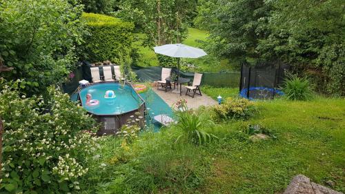 a backyard with a small boat with a table and an umbrella at Chalet Severka Carpe Diem in Rokytnice nad Jizerou