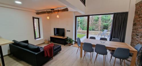 a living room with a table and chairs and a couch at Apartamentos Entrellusa in Perlora