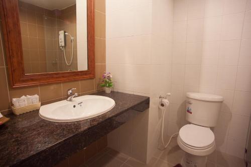 a bathroom with a sink and a toilet and a mirror at Morage Hotel in Phitsanulok