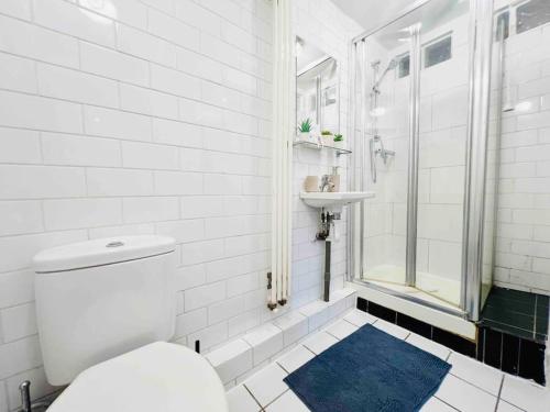 biała łazienka z toaletą i umywalką w obiekcie Highgate Garden Apartment- 2 Bed w Londynie