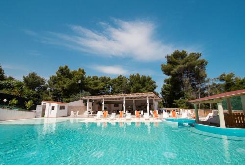 una gran piscina con sillas y un pabellón en Villaggio Elisena, en Vieste