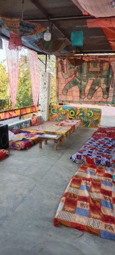 a room with a bunch of blankets and benches at Shanti palce hostel in Pushkar