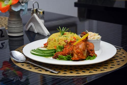 a plate of food with rice and chicken and vegetables at CHILLERS HOTEL AND SUITES in Aiyetoto-Asogun