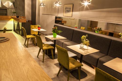 a restaurant with tables and chairs and a couch at Anemos Rooms & Apartments in Nafplio