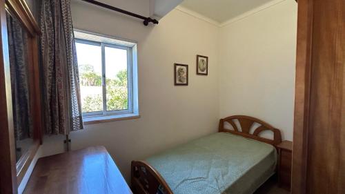 a small bedroom with a table and a window at Casa da Tília in Vale Vazão