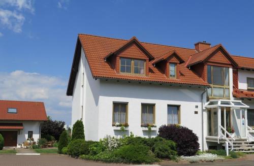 a white house with a red roof at Hotel Erfurtblick in Erfurt