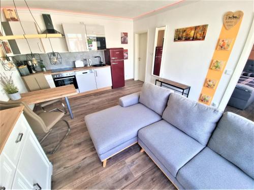 ein Wohnzimmer mit einem Sofa und einer Küche in der Unterkunft Pferdeglück Pappenheimer in Oettingen in Bayern