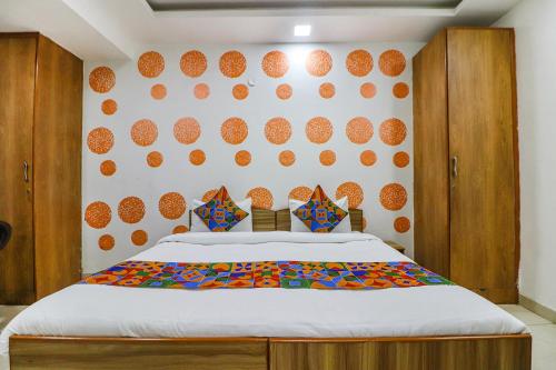 新德里的住宿－FabExpress Abode Inn，一间卧室配有一张床,墙上有橙子