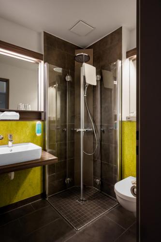 a bathroom with a shower and a sink and a toilet at Radlon Fahrrad-Komfort-Hotel in Waren