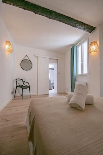 une chambre blanche avec un grand lit et une fenêtre dans l'établissement T2 moderne et lumineux au cœur du centre historique, à Aix-en-Provence
